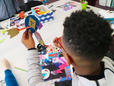 Adolescent en train d'ensembles de pieces en carton pour faire une sculpture colorée