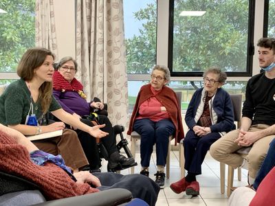 Groupe de personnes âgées assis en cercle, en train de parler lors d'un atelier de philosophie.
