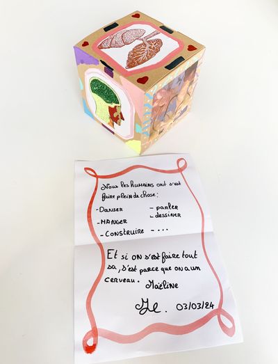 Boite en carton décorée avec des images et un message ecrit sur papier