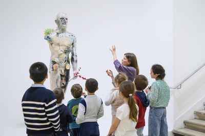 Un philosophe et un groupe d'enfants qui regardent une sculpture